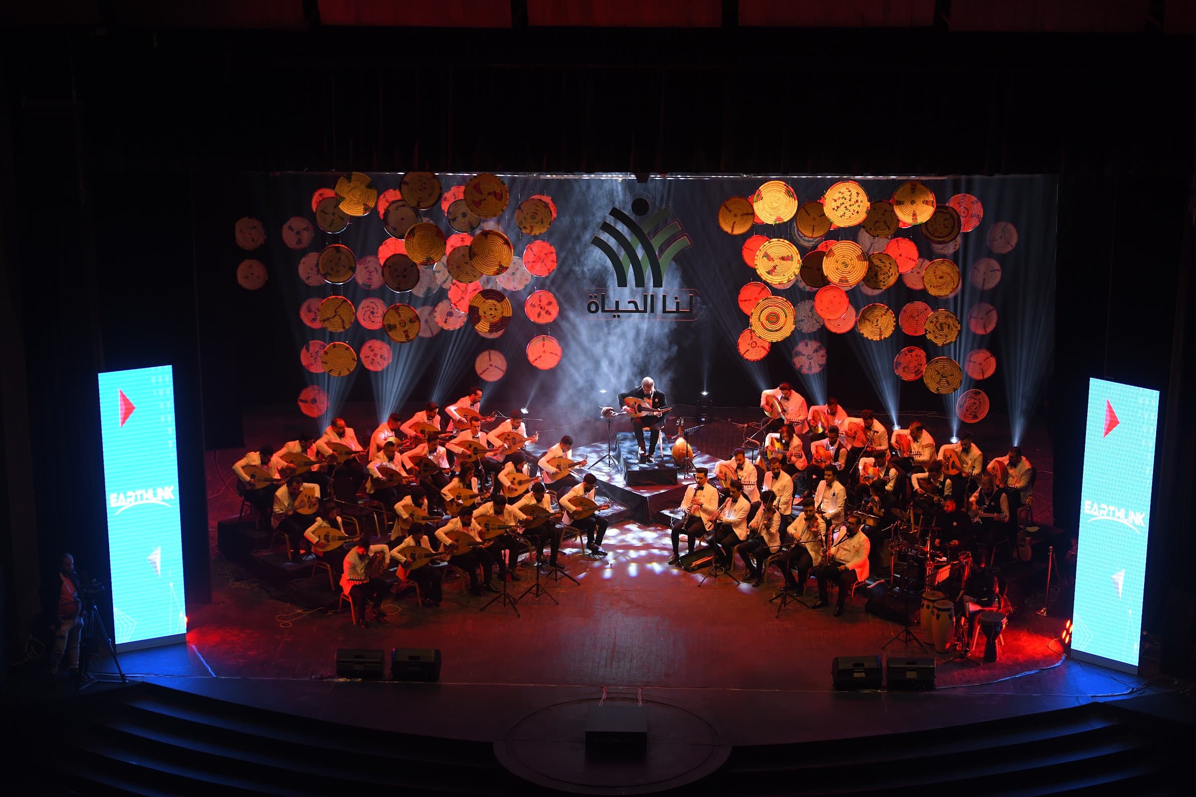 Oud orchestra under theatrical light at the hologram concert